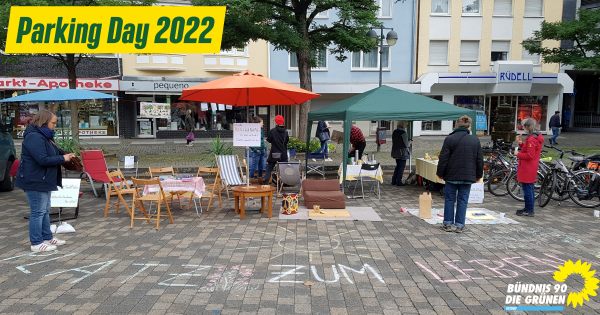 Oben links steht der Text 'Parking Day 2022' in grün auf gelbem Hintergrund. Auf dem Bild an sich ist der Eitorfer Marktplatz zu erkennen und einige Personen auf Stühlen.